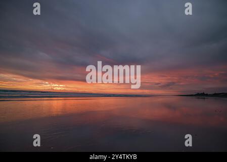 Muriwai Beach bei Sonnenuntergang mit bunten Wolken, Neuseeland, Ozeanien Stockfoto