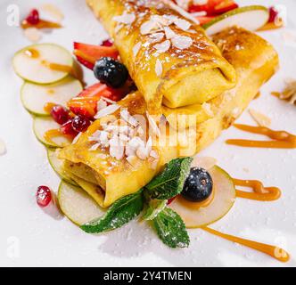 Kunstvoll beschichtete Crepes mit Fruchtgarnituren und Karamellbesatz Stockfoto