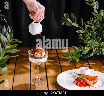 Person, die Sauce auf Eis und san sebastian Käsekuchen tränkt Stockfoto