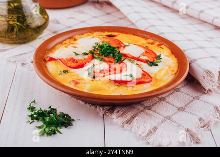 Köstliche italienische Gnocchi mit Mozzarella und Tomaten werden auf einem rustikalen weißen Holztisch serviert Stockfoto