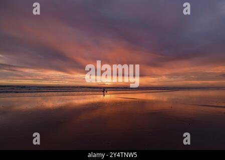 Muriwai Beach bei Sonnenuntergang mit bunten Wolken, Neuseeland, Ozeanien Stockfoto