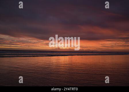 Muriwai Beach bei Sonnenuntergang mit bunten Wolken, Neuseeland, Ozeanien Stockfoto