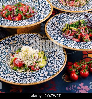 Teller mit Shopska-Salat, ein traditioneller bulgarischer Salat mit Gurken, Tomaten, Paprika, Zwiebeln und sirene, serviert auf einem Tisch Stockfoto