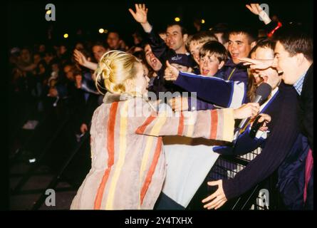 DANNII MINOGUE, CROWD, CARDIFF, BIG NOISE, 1997: TV-Moderator Dannii Minogue trifft die Menge für Interviews und Selfies mit altmodischen Kameras beim BBC Big Noise Festival in Cardiff Bay, Cardiff, Wales, UK am Sonntag, den 11. Mai, 1997. Foto: Rob Watkins Stockfoto