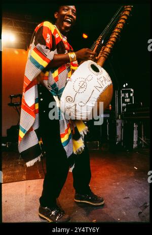 KORA INSTRUMENT, KONZERT, 1997: Afro Celt Sound System spielt ein riesiges Kora Instrument beim Cardiff Big Weekend Festival on Museum Rwns in Cardiff, Wales, UK am 10. August 1997. Foto: Rob Watkins. INFO: Afro Celt Sound System, eine Pioniergruppe, die in den 90er Jahren gegründet wurde, verschmolz traditionelle afrikanische und keltische Musik mit elektronischen Beats und globalen Einflüssen. Ihre aufregende Fusion, die in Tracks wie „Release“ und „When You're Falling“ präsentiert wird, schafft eine transzendente musikalische Reise, die Grenzen überwindet. Stockfoto