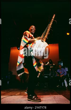 KORA INSTRUMENT, KONZERT, 1997: Afro Celt Sound System spielt ein riesiges Kora Instrument beim Cardiff Big Weekend Festival on Museum Rwns in Cardiff, Wales, UK am 10. August 1997. Foto: Rob Watkins. INFO: Afro Celt Sound System, eine Pioniergruppe, die in den 90er Jahren gegründet wurde, verschmolz traditionelle afrikanische und keltische Musik mit elektronischen Beats und globalen Einflüssen. Ihre aufregende Fusion, die in Tracks wie „Release“ und „When You're Falling“ präsentiert wird, schafft eine transzendente musikalische Reise, die Grenzen überwindet. Stockfoto