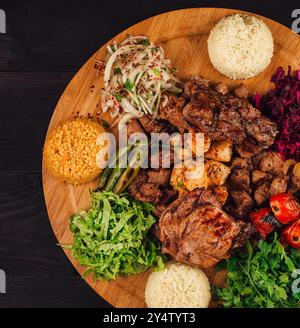 Gegrillte Fleischplatte, die auf einem Holzbrett mit verschiedenen Beilagen serviert wird, perfekt zum Teilen mit Freunden und Familie Stockfoto