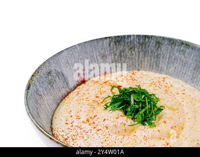 Cremige Polenta mit roten Pfefferflocken und Petersilie in einer Schüssel serviert Stockfoto