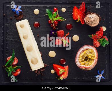 Kunstvoll aufbereitetes Dessert wird mit frischem Obst, Sauce und einer Portion Eis serviert Stockfoto