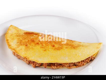 Köstliches Omelette gefüllt mit Hackfleisch liegt auf einem weißen Teller auf weißem Hintergrund Stockfoto