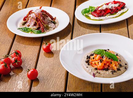 Köstliches italienisches Gourmet-Bruschetta-Sortiment mit frischen Zutaten auf einem rustikalen Tisch mit Holzhintergrund, perfekt für zwangloses Essen und kulinarische Köstlichkeiten Stockfoto