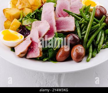 Lebendiger und nahrhafter Nicoise-Salat mit gebratenem Thunfisch, Gemüse, Eiern und Kartoffeln Stockfoto