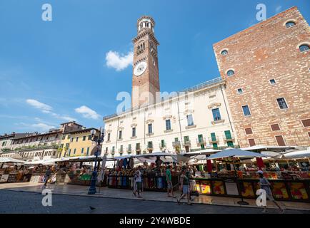 Markt auf dem berühmten Stadtplatz Piazza delle Erbe mit Lamberti-Turm im Hintergrund. Verona, Italien. Stockfoto