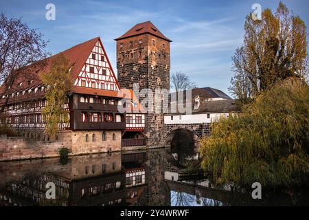 Historisches Gebäude mit Wasserspiegelung in Deutschland. Weinstadel mit Pegnitz am Herbsttag im bayerischen Nürnberg. Stockfoto