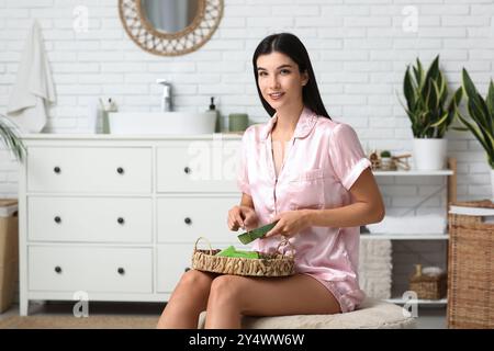 Schöne junge Frau, die Aloe Vera Gel im Badezimmer macht Stockfoto