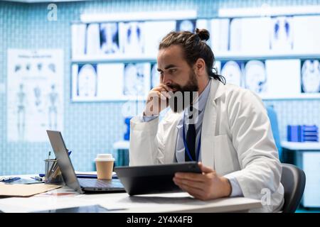 Lizenzierter Spezialist, der radiologische Testergebnisse für eine Behandlungsoption untersucht und die Diagnose zur Heilung in einer Privatklinik findet. Arzt mit Fachwissen, das gute medizinische Leistungen in der Versicherung sicherstellt. Stockfoto