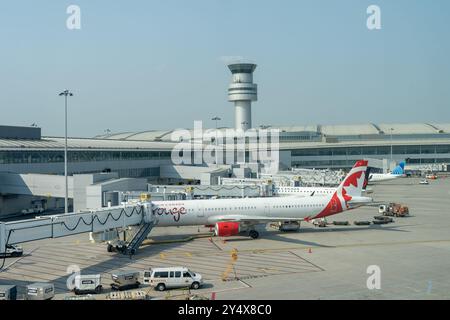 Ein Flugzeug der Air Canada rouge parkte am Toronto Pearson International Airport mit Air Traffic Control Tower im Hintergrund in Mississauga. Stockfoto