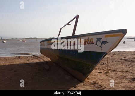 Verwitterte Fischerboote ruhen an einem Sandstrand. Die Boote sind mit wunderschönen Farben bemalt und warten im Sand, um ins Meer zu gelangen Stockfoto