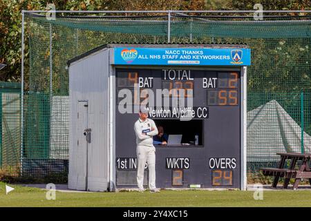 Der Newton Aycliffe Cricket Club war an einem sonnigen Samstagnachmittag Gastgeber des Middlesborough Cricket Club. Fielder steht auf der Grenze vor der Anzeigetafel Stockfoto