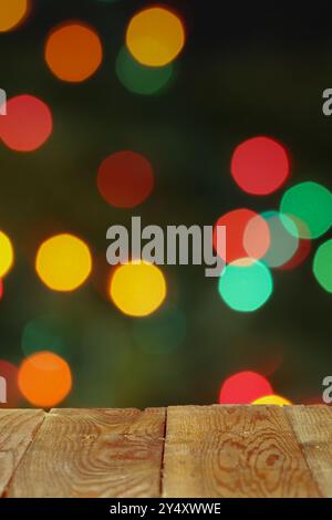 Leerer Holztisch vor verschwommenem Hintergrund der Weihnachtsbeleuchtung Stockfoto