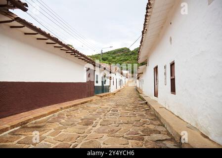 Guane, Santander, Kolumbien; 26. November 2022: Kopfsteingepflasterte Straße mit Häusern historischer Kolonialarchitektur, typisch für diese kleine Touristenstadt. Stockfoto