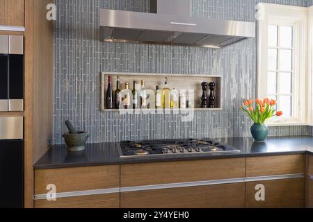 Ecke der modernen Küche mit Kochfeld, Fenster und einzigartigen Fliesen Stockfoto