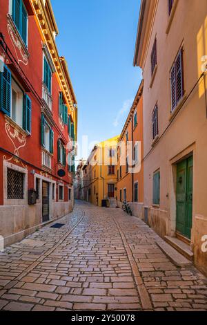 Rovinj, Kroatien - traditionelle farbenfrohe Häuser in einer leeren engen Kopfsteinpflasterstraße in der Altstadt von Rovinj an einem sonnigen Sommermorgen mit klarem blau Stockfoto