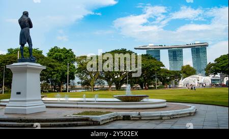 SINGAPUR - APRIL 2024: Blick auf das Marina Bay Sands Hotel und die Statue von Stamford Raffles, dem Gründer von British Singapore, hoch davor Stockfoto