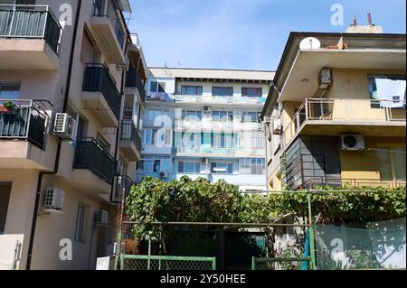 Wohngebäude mit Architektur aus der Mitte des Jahrhunderts inmitten eines lebhaften Stadtviertels im Sommer Stockfoto