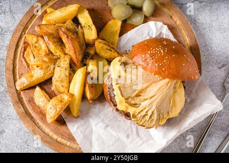 Hamburger mit Austernpilzen und Cheddar auf einem Holzschneidebrett Stockfoto