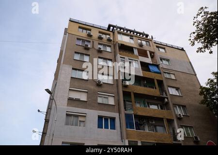 Modernes Apartmentgebäude mit verschiedenen architektonischen Stilen unter klarem Himmel in urbaner Umgebung Stockfoto