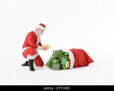 Der weihnachtsmann kniet und nimmt ein weihnachtsgeschenk aus einem Stapel weihnachtsgeschenke, die aus einem Sack überlaufen. 3D-Rendering Stockfoto