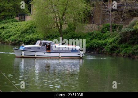 25. April 24 Ein kleiner Kabinen-Kreuzer, der eine Kurve auf dem Fluss Avon in der City of Bath Somerset in England aushält. Stockfoto