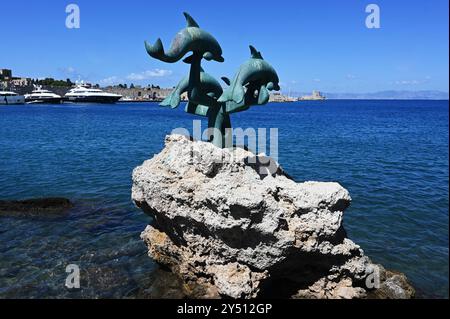 Griechische Inseln. Hafen der Insel Rhodos in Griechenland. Delfin-Denkmal im Meer vor der Stadtmauer von Rhodos-Altstadt. Der Mythologie zufolge soll Rhodos aus dem Meer entstanden sein *** griechische Inseln Hafen der Insel Rhodos in Griechenland Delphinstatue oder Delphindenkmal im Meer vor der Stadtmauer der Altstadt von Rhodos nach der Mythologie wurde Rhodos aus dem Meer geschaffen Stockfoto