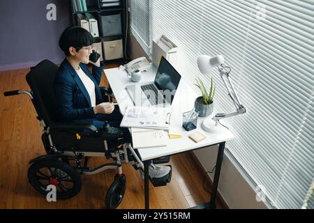 Geschäftsfrau Diskutiert Am Telefon Über Finanzdiagramme Stockfoto