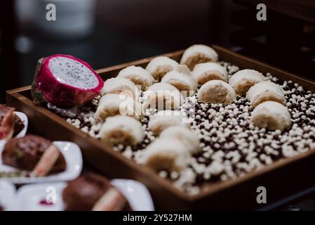 Verschiedene Desserts auf einem Buffet mit Drachenobst-Beilage. Stockfoto
