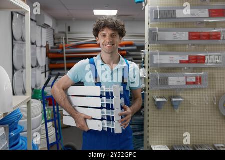 Porträt von glücklich lächelndem, zufriedenem Klempner, der den Heizkörper hält Stockfoto