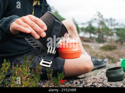 Mann gießt kochendes Wasser in eine Tasse für Kaffee draußen Stockfoto