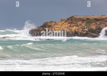 Wellen schlagen in Warrnambool gegen die orangefarbenen, zerklüfteten Klippen Stockfoto