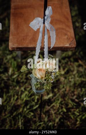 Hochzeitsdekor im Landhausstil mit Rosen, Spitzenband und Kamille in einem Glas. Stockfoto