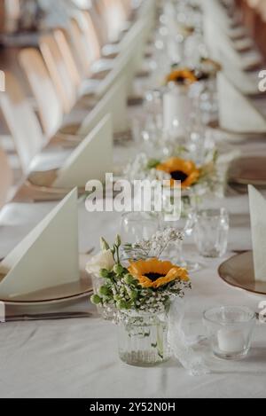Hochzeitstisch mit Sonnenblumen- und Rosenmitten im rustikalen Stil Stockfoto