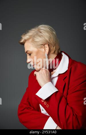 Eine stilvolle Frau in Rot und weiß posiert anmutig und stellt ihr selbstbewusstes Profil zur Schau. Stockfoto