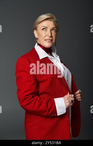 Eine Erwachsene Frau mit rotem Blazer und stilvoller Bluse strahlt Selbstvertrauen und Eleganz aus. Stockfoto