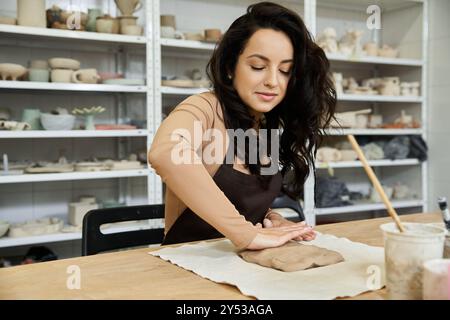 Hübsche Frau am Tisch, die Töpferei macht. Stockfoto