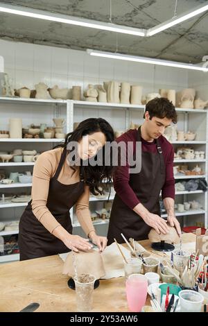 Ein Paar formt fröhlich Ton an einem Töpfertisch. Stockfoto