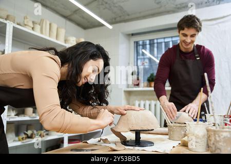 Ein Paar formt fröhlich Ton in einem hellen, einladenden Studio. Stockfoto