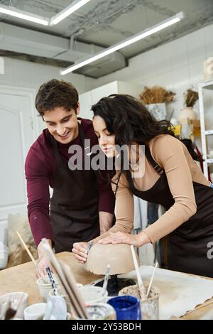 Ein Paar bastelt fröhlich Töpferwaren in einem modernen Studio. Stockfoto