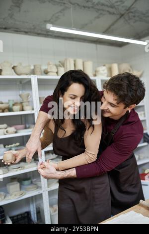 Ein Paar bastelt fröhlich Keramik, teilt Lächeln und Kreativität. Stockfoto