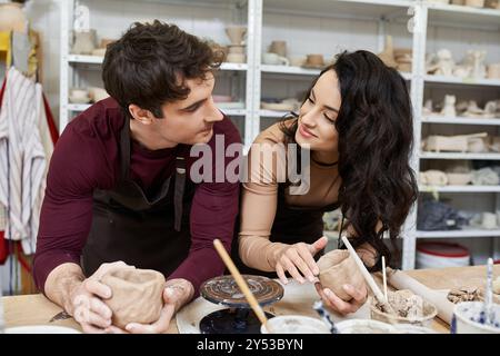 Ein liebevolles Paar bastelt Töpferwaren und teilt dabei ein Lächeln in einem lebendigen Studio. Stockfoto