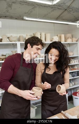 Ein Paar bastelt fröhlich Töpferei zusammen, teilt Lächeln und Kreativität. Stockfoto